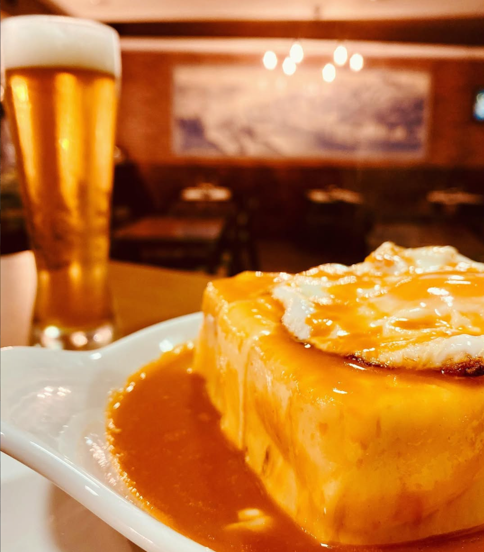 Francesinha Oporto servida com molho e cerveja
